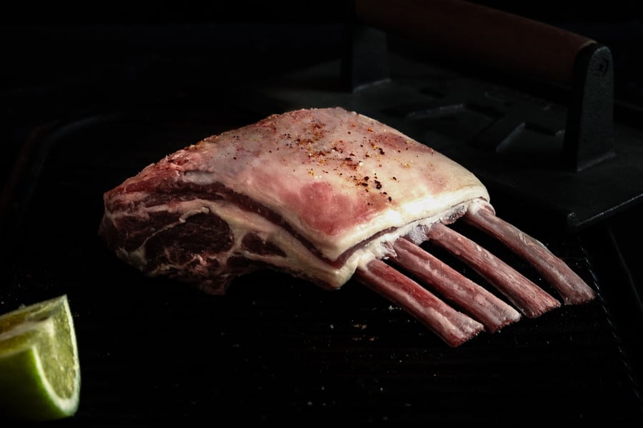 French-trimmed rack of lamb on a dark surface