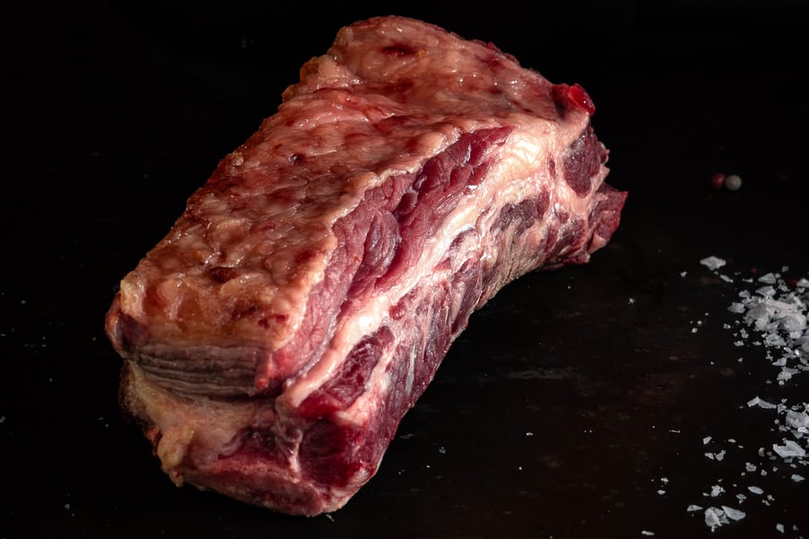 Beef short rib joint on a dark surface